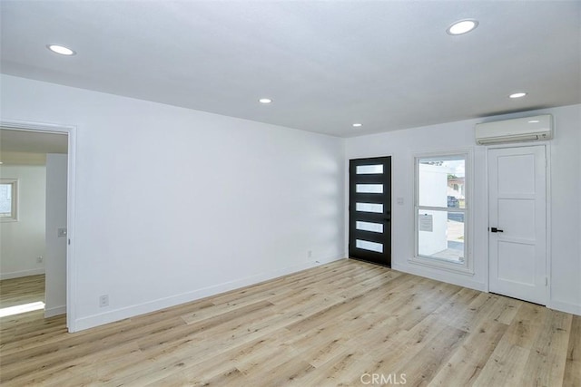 entrance foyer featuring light wood-style floors, recessed lighting, baseboards, and a wall unit AC