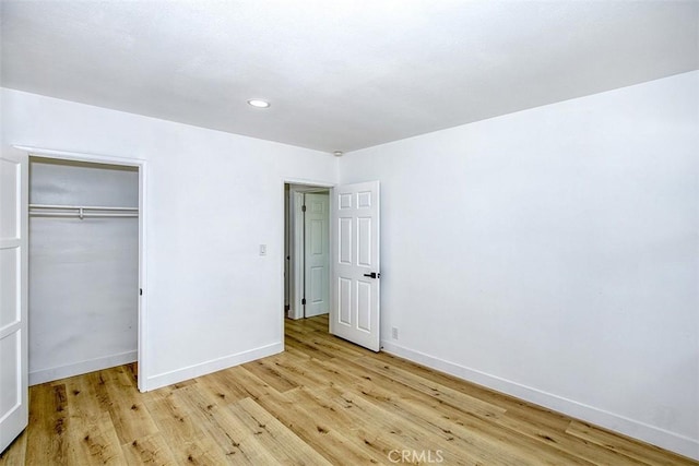 unfurnished bedroom with recessed lighting, baseboards, a closet, and light wood-type flooring