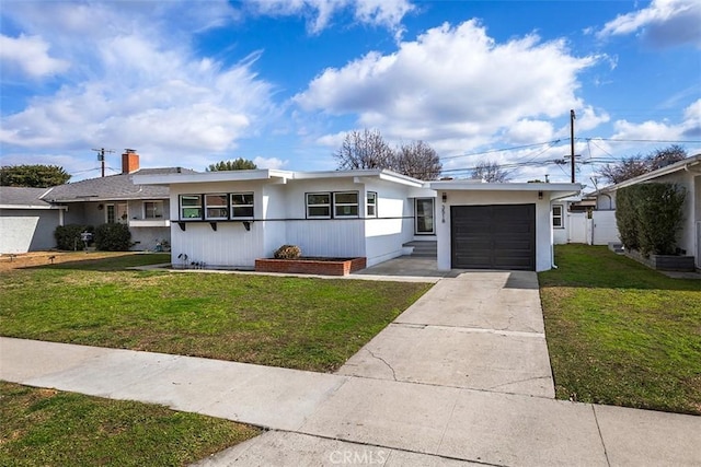 single story home featuring an attached garage, concrete driveway, and a front lawn