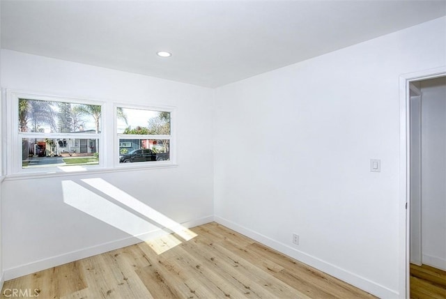 spare room with recessed lighting, baseboards, and wood finished floors
