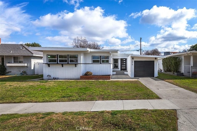 single story home with an attached garage, a front yard, and concrete driveway