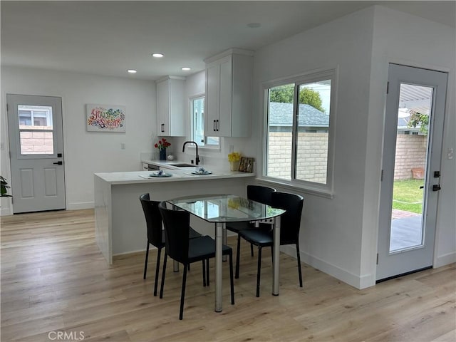 dining space with recessed lighting, baseboards, and light wood-type flooring