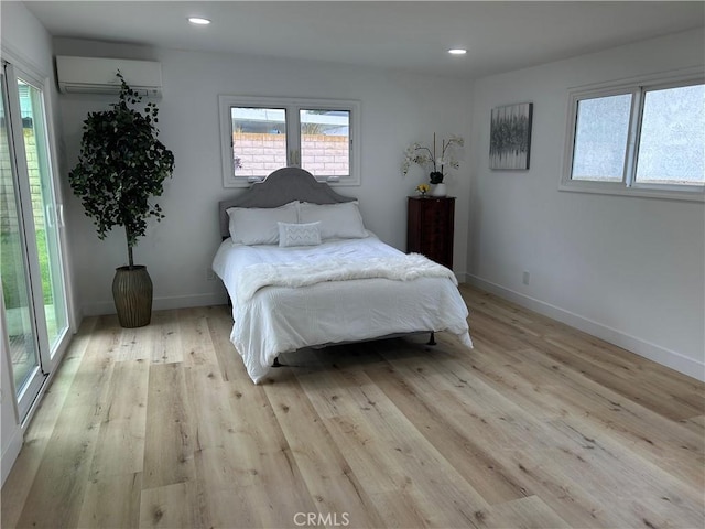 bedroom featuring light wood-type flooring, a wall mounted air conditioner, baseboards, and recessed lighting