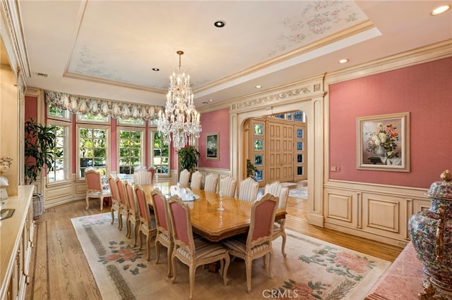 4537 Ellenboro Way, Woodland Hills, CA 91364 - dining room featuring a tray ceiling, crown molding, a chandelier, light wood-style floors, and wainscoting