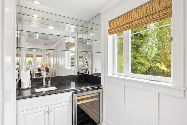 bar featuring beverage cooler, indoor wet bar, and a sink