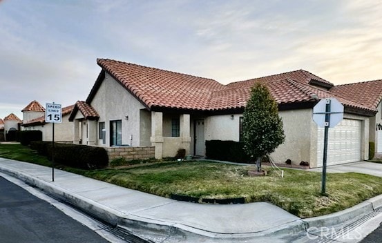 19238 Olive Way, Apple Valley, CA 92308 - mediterranean / spanish house featuring a tile roof, a garage, concrete driveway, and stucco siding