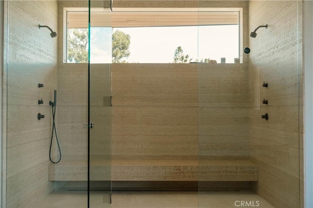 bathroom featuring plenty of natural light and tiled shower