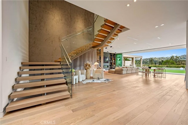 stairs featuring expansive windows and wood finished floors