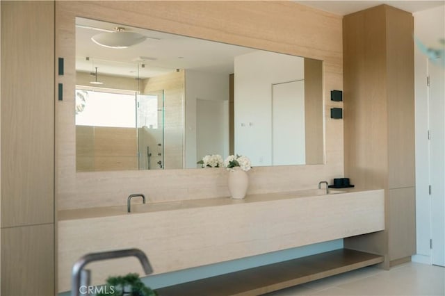 bathroom with double vanity and a shower stall