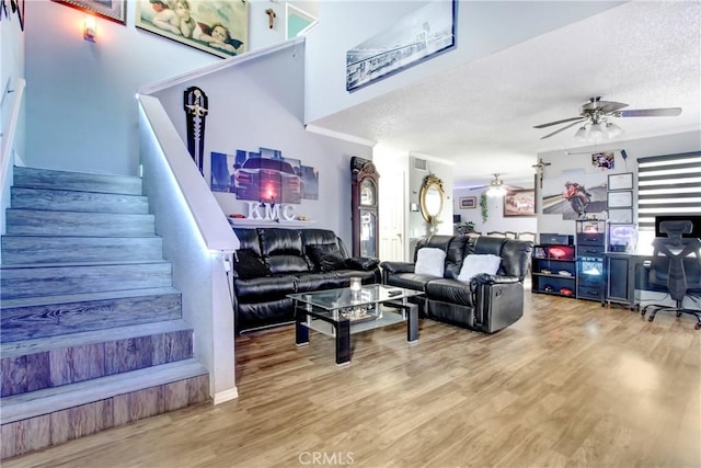 7801 Pinyon Ave, Fontana, CA 92336 - living area featuring a ceiling fan, a textured ceiling, stairs, and wood finished floors