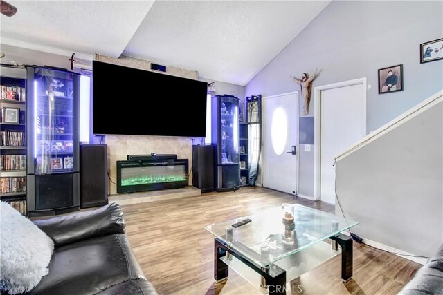 7801 Pinyon Ave, Fontana, CA 92336 - living area featuring vaulted ceiling, wood finished floors, and a fireplace