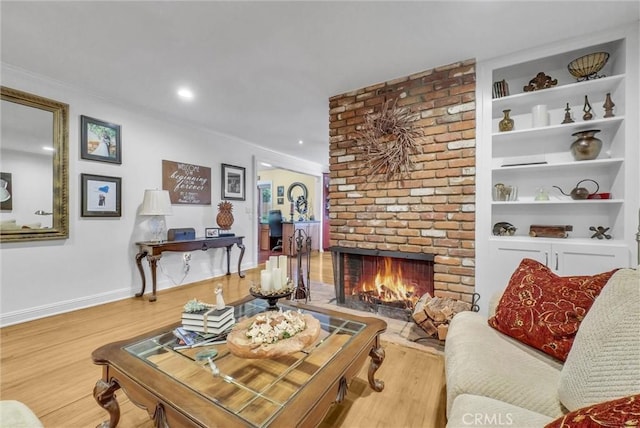 19903 E Rambling Rd, Covina, CA 91724 - living area featuring a brick fireplace, wood finished floors, crown molding, baseboards, and built in shelves