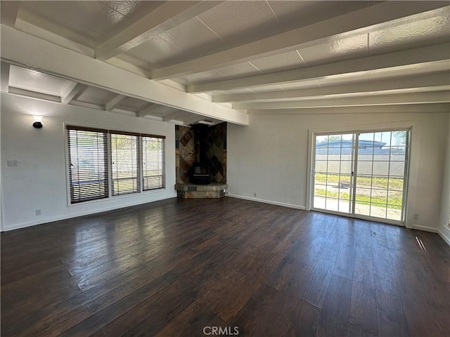 unfurnished living room featuring dark wood-style flooring, beam ceiling, and baseboards