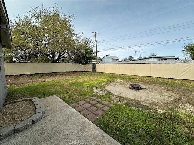 view of yard featuring an outdoor fire pit and a fenced backyard