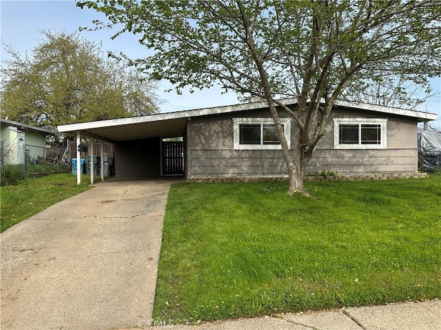 view of front of home with fence, a front lawn, concrete driveway, and a carport
