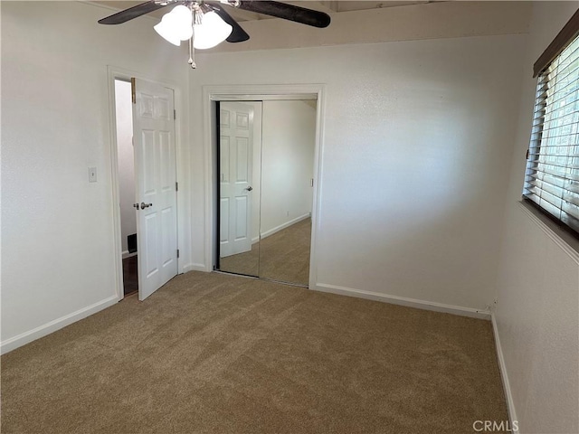 unfurnished bedroom featuring baseboards, carpet floors, ceiling fan, and a closet