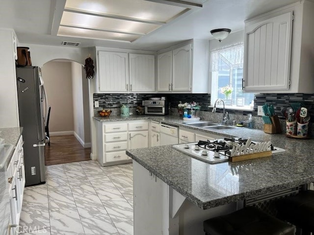 14610 Apple Valley Rd, Apple Valley, CA 92307 - kitchen featuring a peninsula, freestanding refrigerator, arched walkways, white dishwasher, and a sink