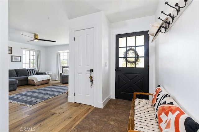 foyer entrance featuring baseboards, a ceiling fan, and wood finished floors