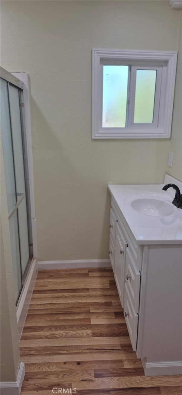 9714 San Benito Ave, Gerber, CA 96035 - bathroom with a shower stall, vanity, baseboards, and wood finished floors