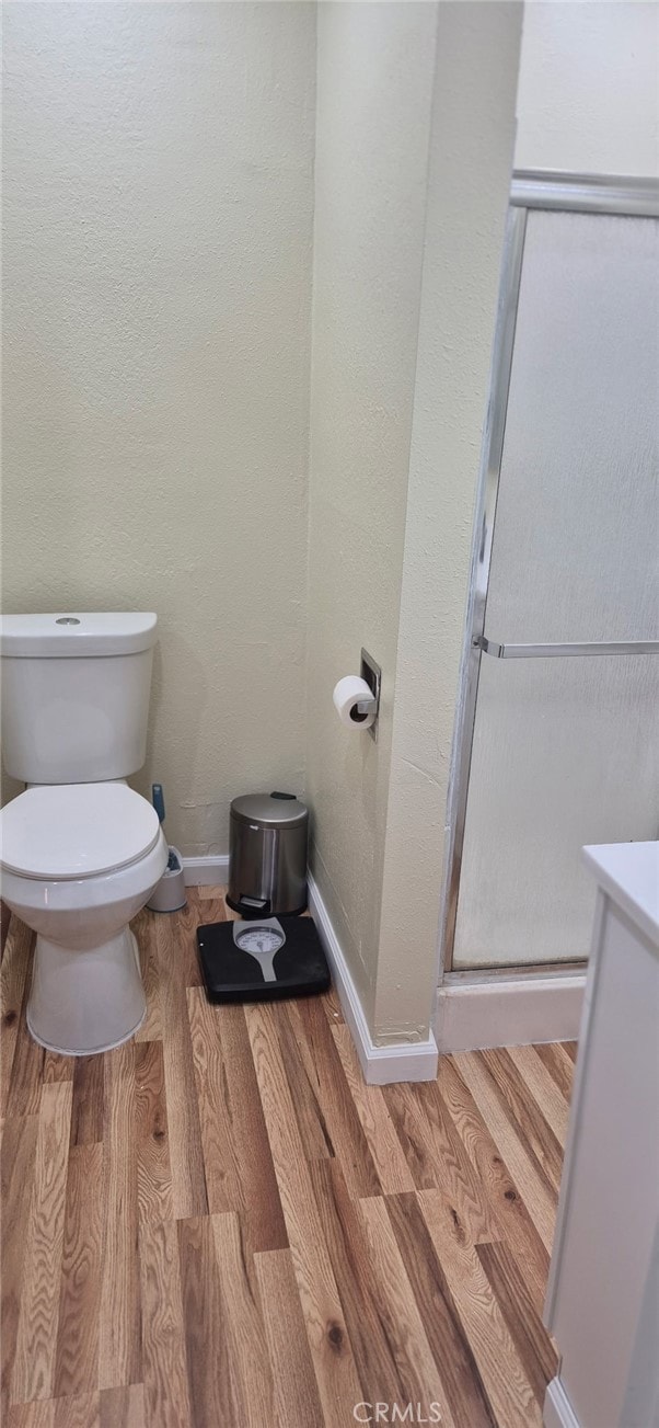 9714 San Benito Ave, Gerber, CA 96035 - bathroom featuring a stall shower, baseboards, toilet, and wood finished floors