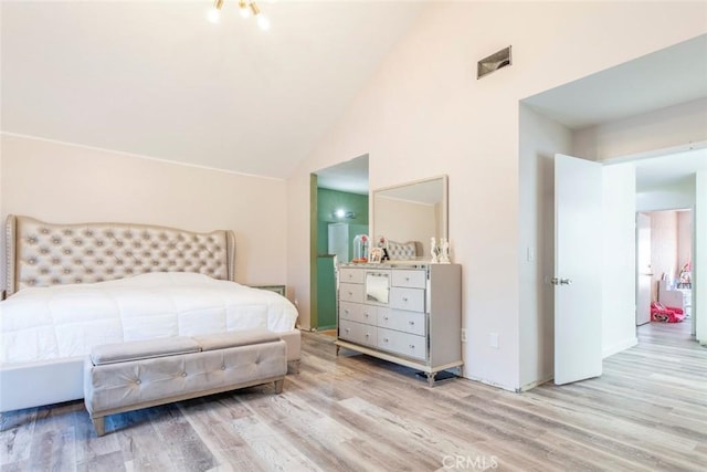 bedroom with visible vents, wood finished floors, and vaulted ceiling