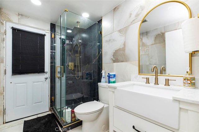 full bathroom with recessed lighting, tile walls, toilet, vanity, and a marble finish shower