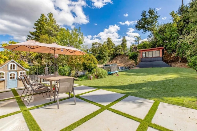 view of patio / terrace with a trampoline and outdoor dining space
