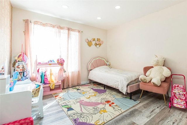 bedroom with recessed lighting and wood finished floors