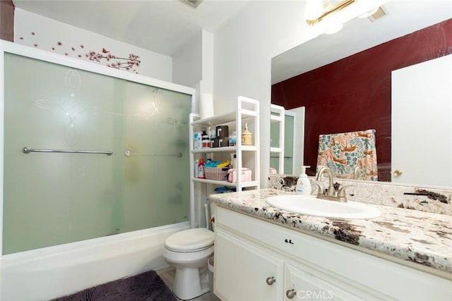 full bathroom featuring bath / shower combo with glass door, vanity, and toilet