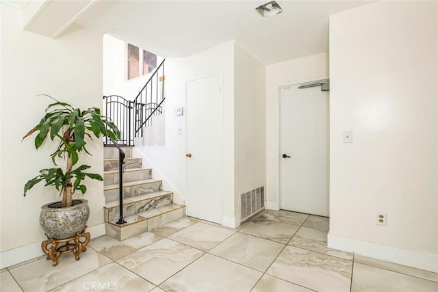 stairs with visible vents, marble finish floor, and baseboards