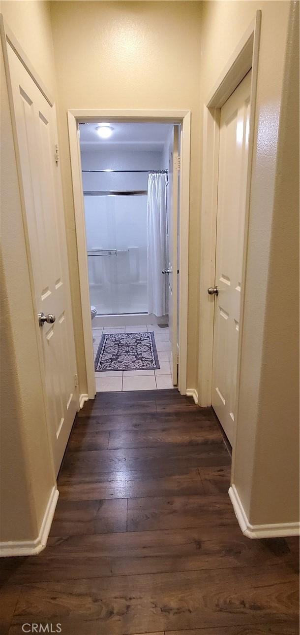 hall with baseboards and dark wood-style flooring