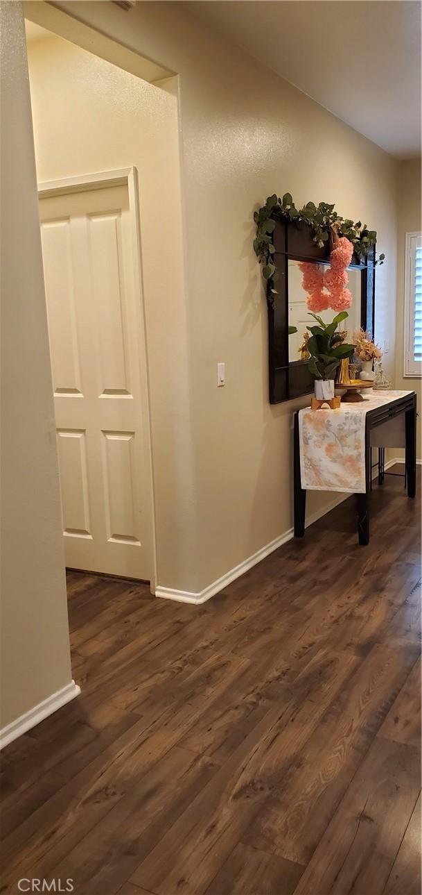 hall with dark wood-style floors and baseboards