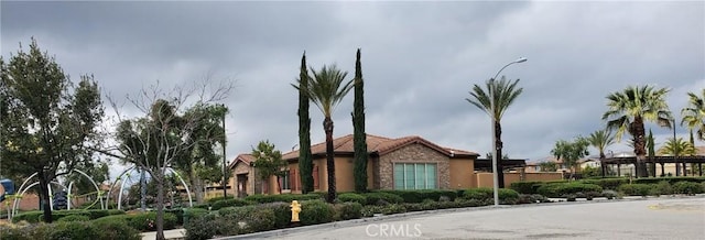 view of side of home featuring stucco siding and a tiled roof