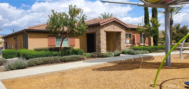 exterior space featuring stucco siding and a tiled roof