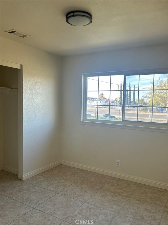 empty room featuring baseboards and visible vents