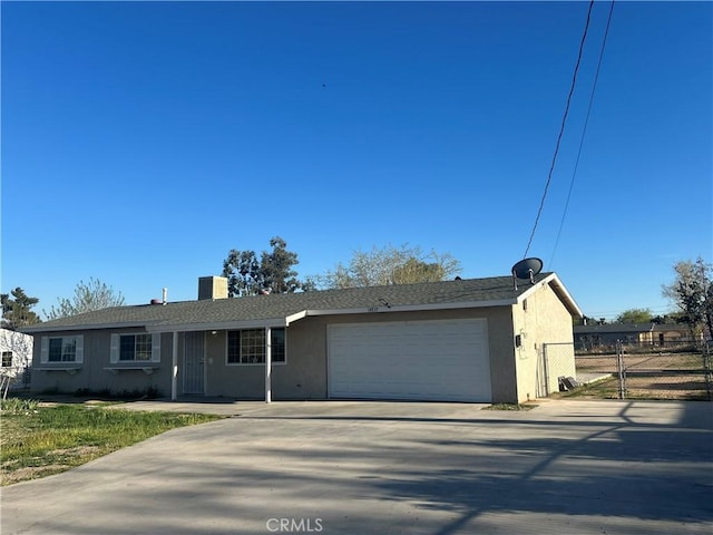 ranch-style home featuring concrete driveway, fence, stucco siding, and a garage