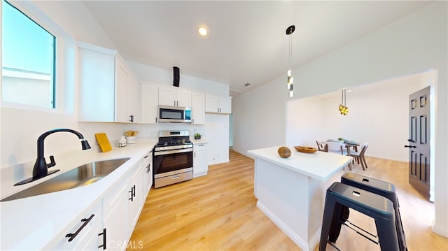 411 W Plum St, Compton, CA 90222 - kitchen featuring stainless steel appliances, a sink, light countertops, white cabinets, and a kitchen island