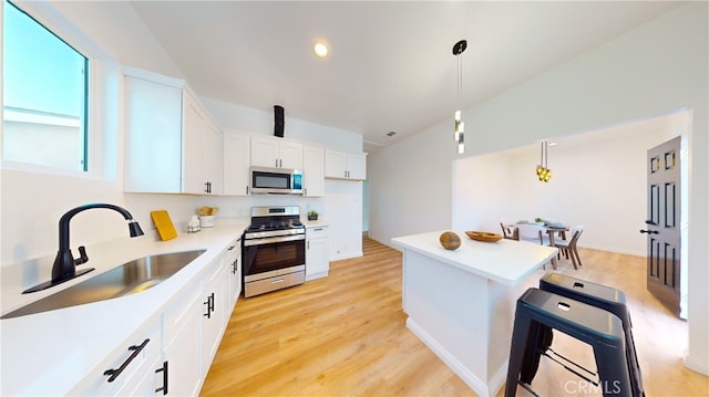 411 W Plum St, Compton, CA 90222 - kitchen with appliances with stainless steel finishes, a sink, light countertops, white cabinets, and a kitchen island