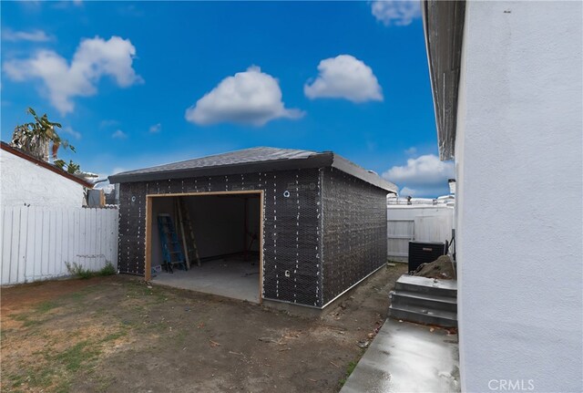 411 W Plum St, Compton, CA 90222 - view of home's exterior with fence, a detached garage, an outbuilding, brick siding, and cooling unit