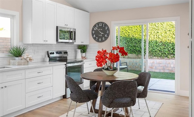 10620 Gemini Dr, Riverside, CA 92503 - kitchen with light wood-style floors, decorative backsplash, light countertops, and stainless steel appliances
