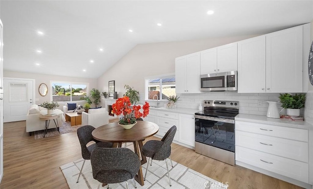 10620 Gemini Dr, Riverside, CA 92503 - kitchen with white cabinets, stainless steel appliances, a healthy amount of sunlight, and tasteful backsplash