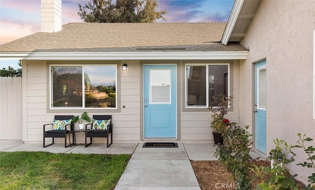 10620 Gemini Dr, Riverside, CA 92503 - exterior entry at dusk with roof with shingles and a chimney