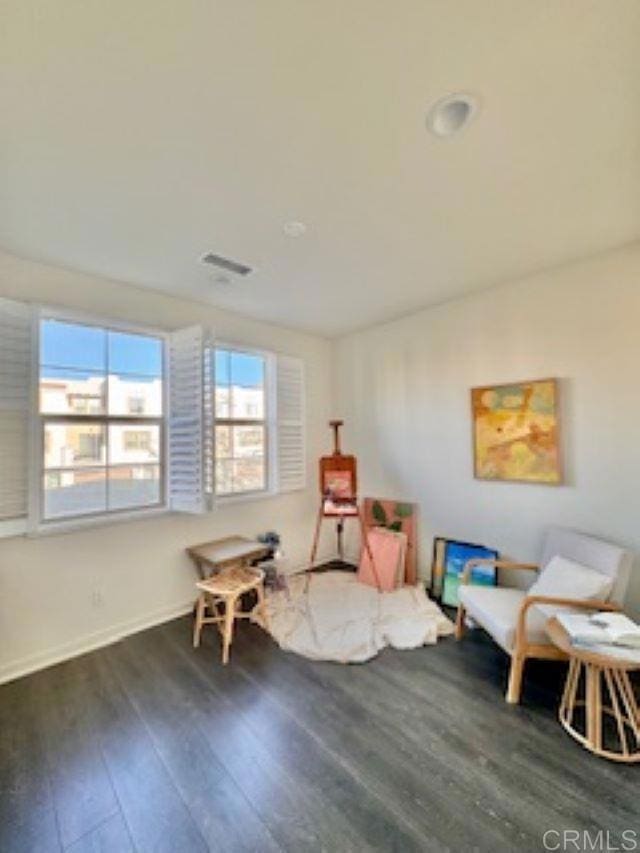 sitting room featuring wood finished floors, visible vents, and baseboards