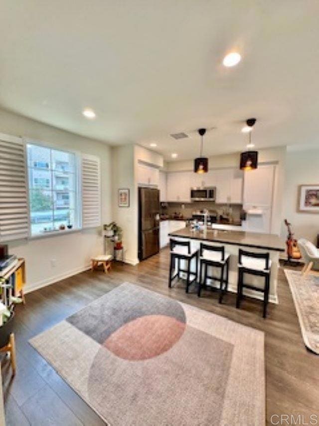 living room with recessed lighting, baseboards, and dark wood-style flooring