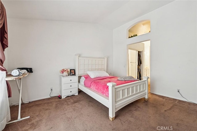 carpeted bedroom with baseboards and vaulted ceiling