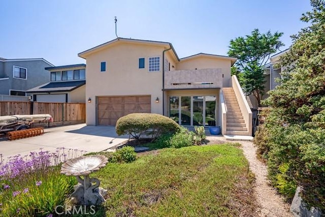 2062 Sherwood Dr, Cambria, CA 93428 - rear view of house featuring stairway, a garage, stucco siding, and driveway