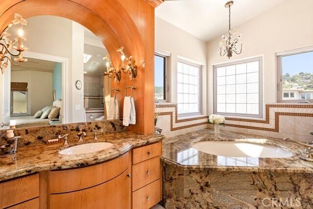 2062 Sherwood Dr, Cambria, CA 93428 - bathroom with vanity, a bath, a chandelier, and vaulted ceiling
