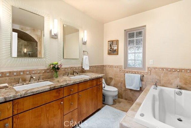 2062 Sherwood Dr, Cambria, CA 93428 - full bath featuring a garden tub, double vanity, toilet, tile walls, and tile patterned flooring
