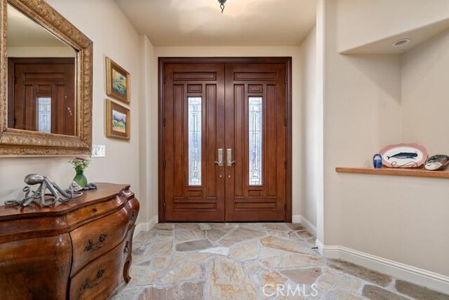 2062 Sherwood Dr, Cambria, CA 93428 - foyer entrance featuring light stone finish floors and baseboards