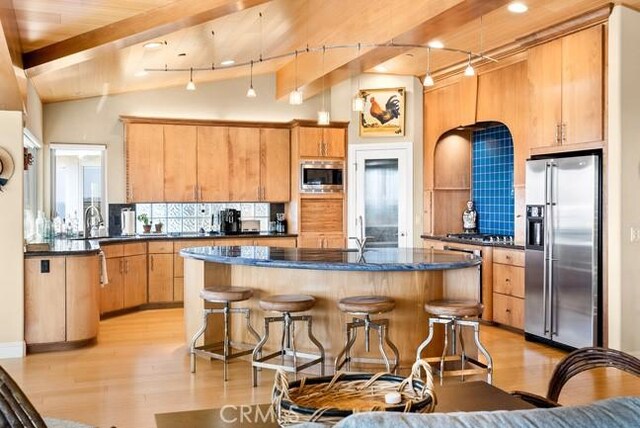 2062 Sherwood Dr, Cambria, CA 93428 - kitchen featuring stainless steel appliances, light wood finished floors, backsplash, and a breakfast bar